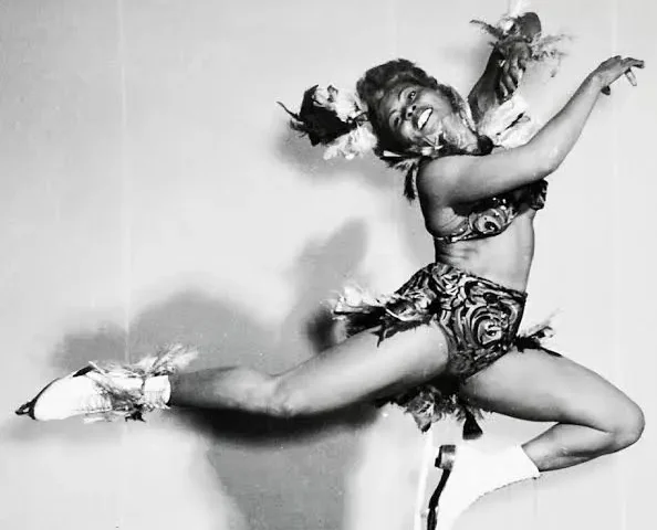 Mabel Fairbanks mid-leap in a feathered show costume during an ice revue performance