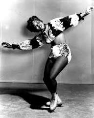 Mabel Fairbanks in a patterned show costume, hand raised to her head, during an ice show performance