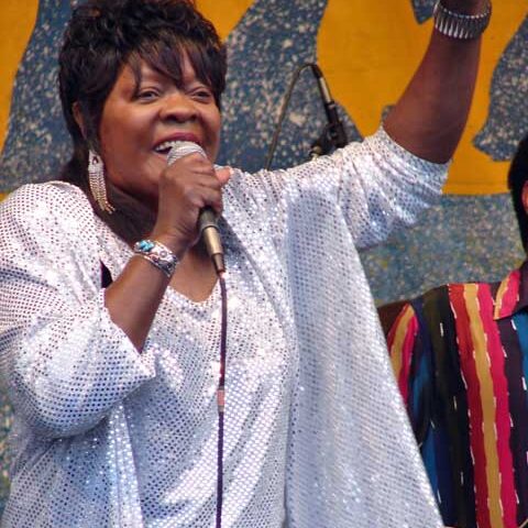 Koko Taylor performing at the New Orleans Jazz & Heritage Festival, 2006, in a sparkling outfit, mid-song.